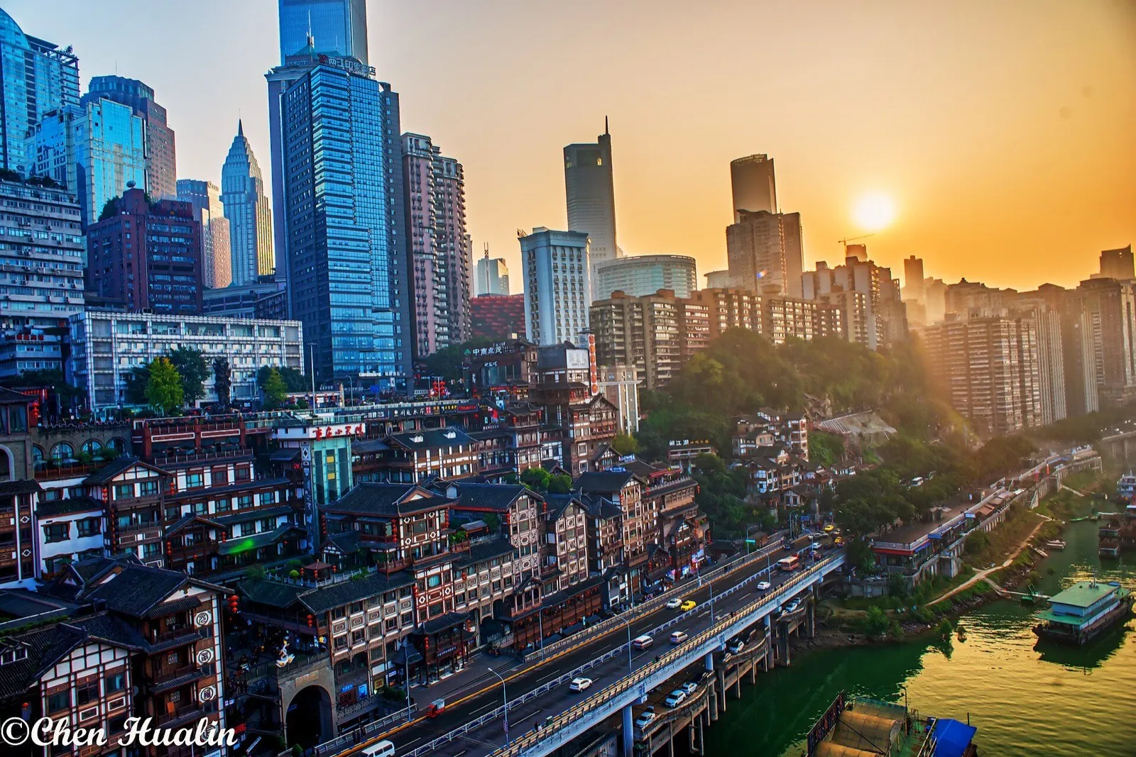 Hongya Cave's golden stilted towers glowing above the Jialing River at night, with bridge lights in the distance