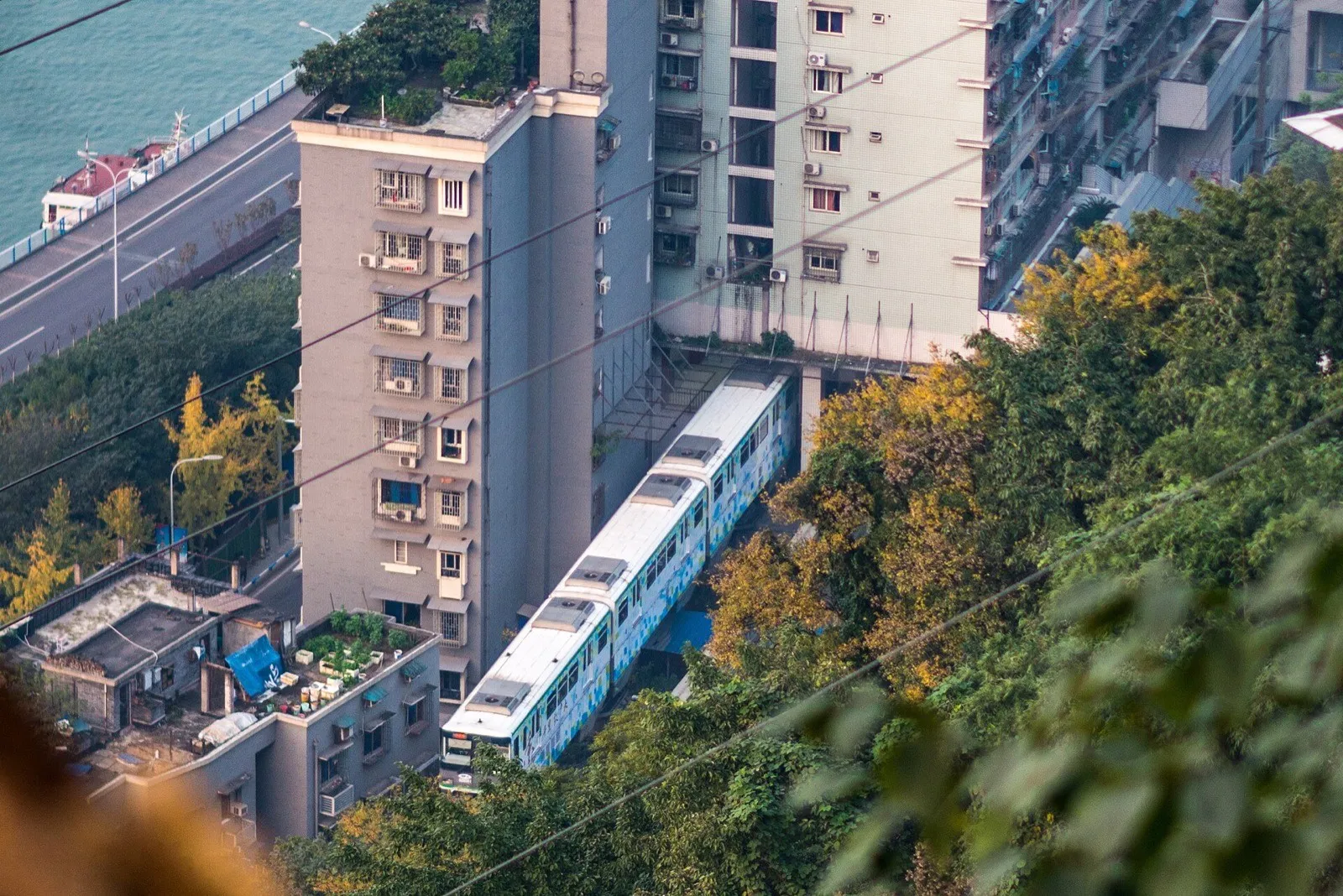 A Chongqing Rail Transit Line 2 metro train passing through a residential building at Liziba station