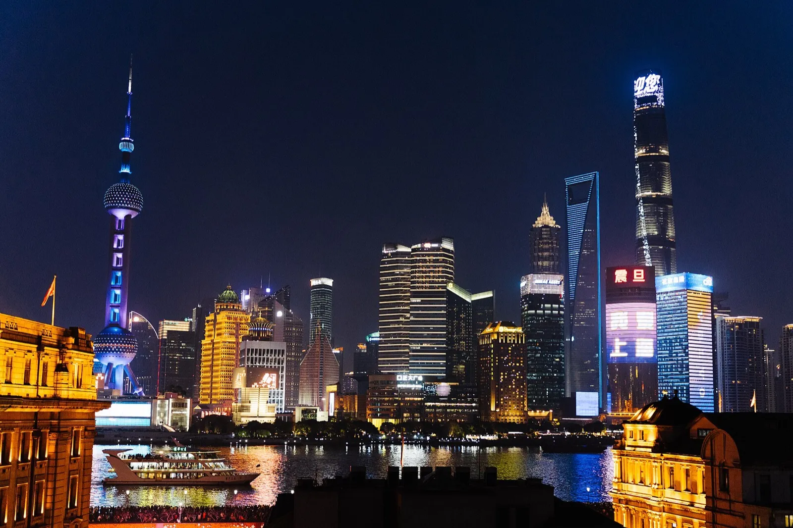 A traveler checking a smartphone on a city street in China at night, neon signs blurred in the background