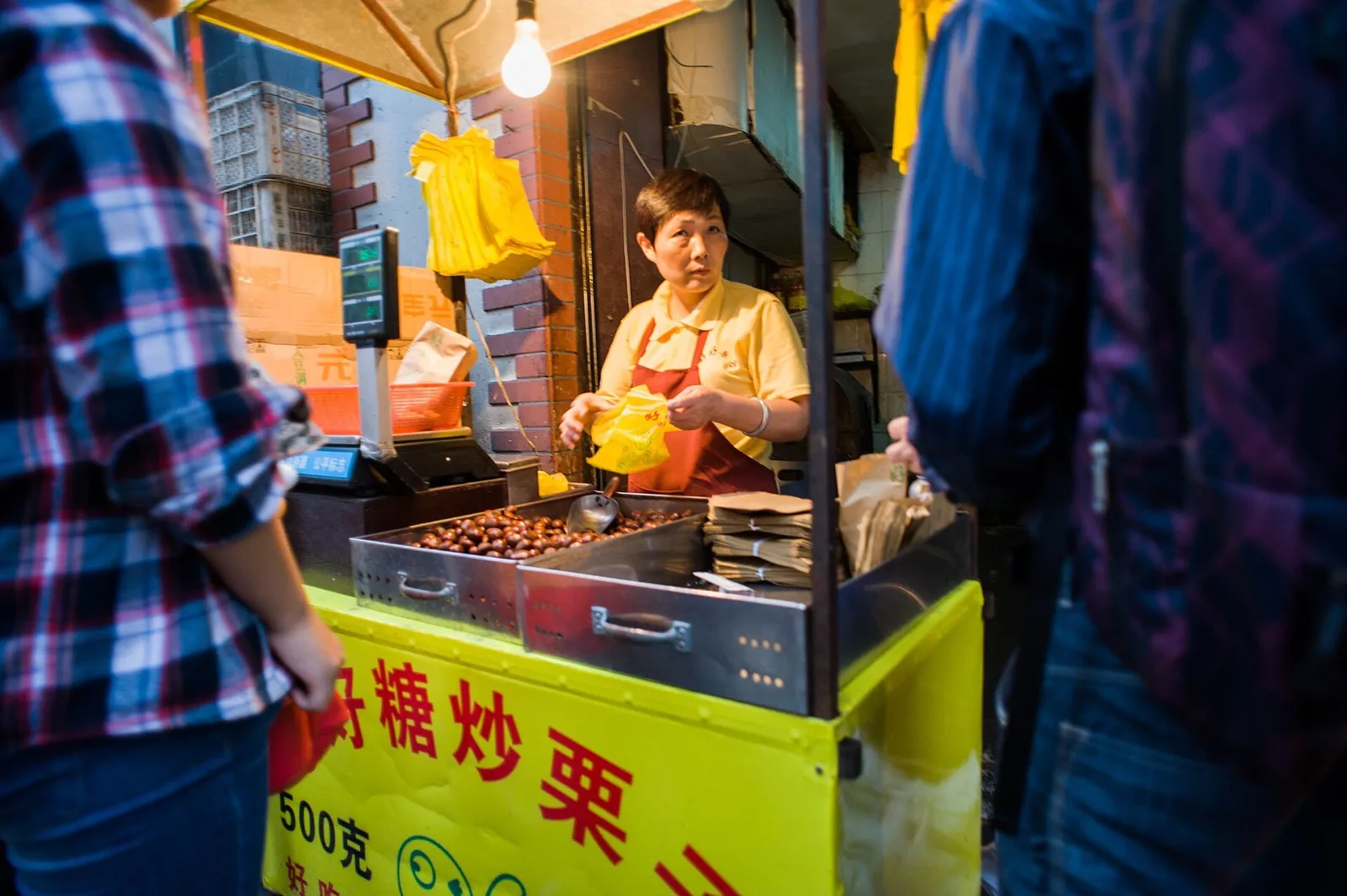 A traveler pointing a phone camera at a Chinese street sign with a translation app overlaying English text
